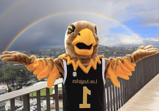 Eddie the Golden Eagle with arms spread out pretending to hold a rainbow.