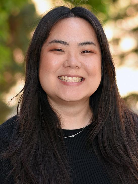 A person with long hair smiling