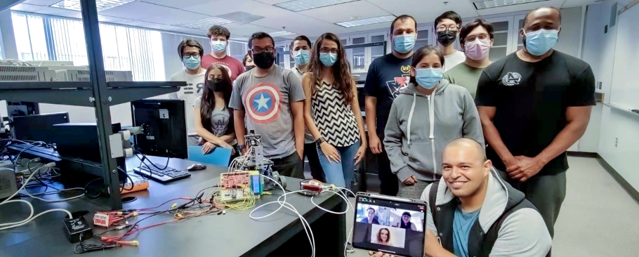 students smile in lab with project