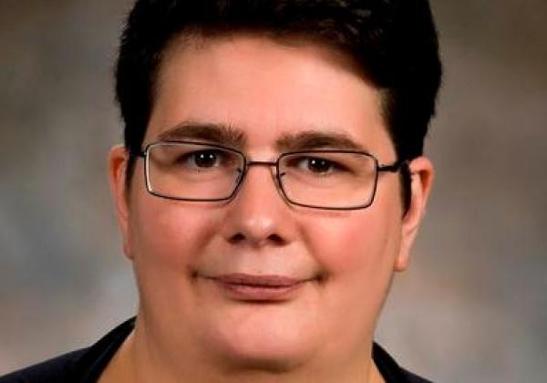 Woman with dark hair and glasses portrait.