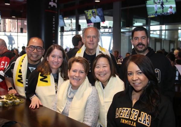 Group shot of seven alumni smiling