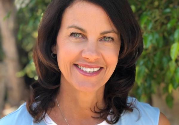 Portrait of a woman wearing light blue shirt smiling. 