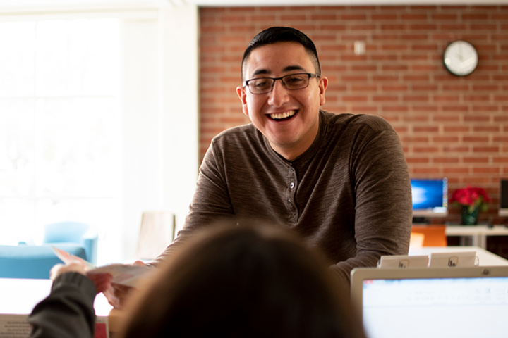 Student worker helps a student at a department front desk