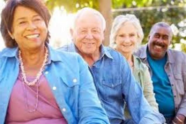 Elderly people sitting outside smiling 